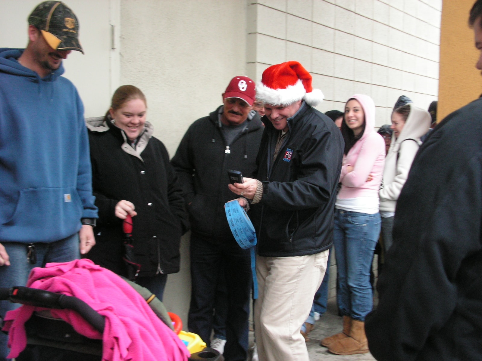 Ken in Santa hat with crowd at outdoor holiday event