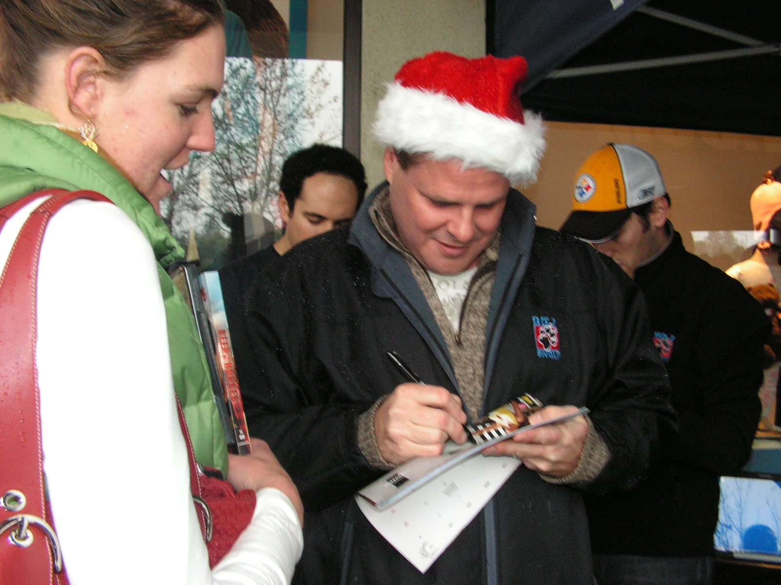 Ken in Santa hat signing autographs for fans